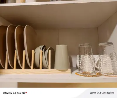 a shelf with plates and vases on it at K&C Suite in Trece Martires