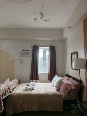 a bedroom with a bed and a window at K&C Suite in Trece Martires