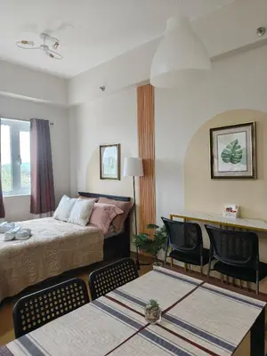 a hotel room with a bed and a table and chairs at K&C Suite in Trece Martires