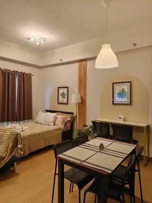 a bedroom with a bed and a table and chairs at K&C Suite in Trece Martires