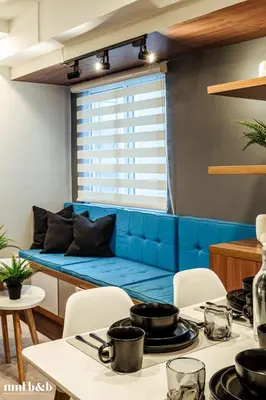 a blue couch in a living room with a table at UP TO 6 PAX! Spacious Loft 2 BR near High Street, BGC Fort Victoria The Fort, Taguig City in Manila