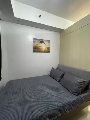 a bedroom with a bed with a picture on the wall at Sea Residences 1BR Stays - Near Airport & MOA Pasay in Manila
