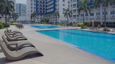 a large swimming pool in a large building at Sea Residences 1BR Stays - Near Airport & MOA Pasay in Manila