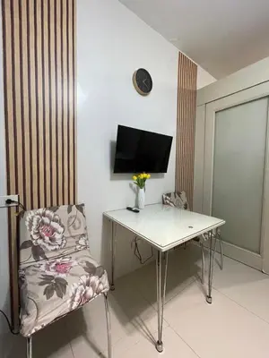 a room with a desk with a chair and a television at Sea Residences 1BR Stays - Near Airport & MOA Pasay in Manila