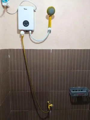 a shower with a hose attached to a wall at Jace Haven 1 Room 2 Beds in Binangonan