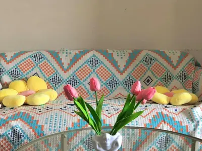 a table with a vase of flowers on a couch at Hub Metro in makati 100west 1br with balcony in Manila