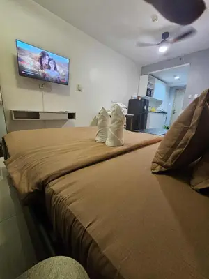 a bedroom with a large bed with a tv on the wall at Shore Residences Sm mall of asia Marc in Manila