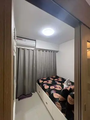 a small bedroom with a bed and a curtain at Shore Residences Sm mall of asia Marc in Manila