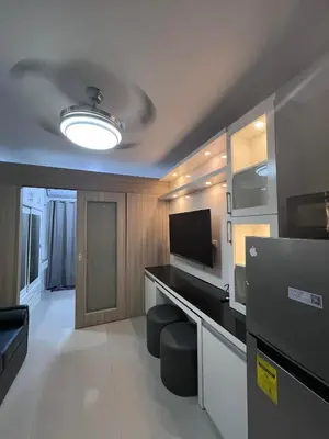 a room with a living room with a television and a room at Shore Residences Sm mall of asia Marc in Manila