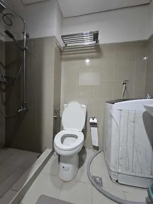 a bathroom with a toilet and a bath tub at Shore Residences Sm mall of asia Marc in Manila
