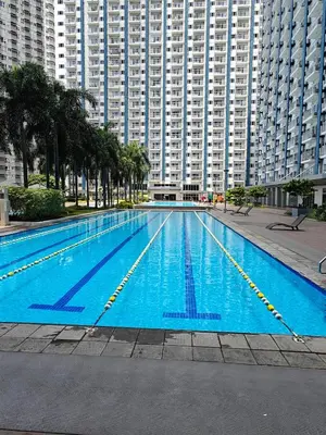 a large swimming pool in front of a large building at Cozy Modern 1BR Light Residences with 55 inches 4K TV in Manila