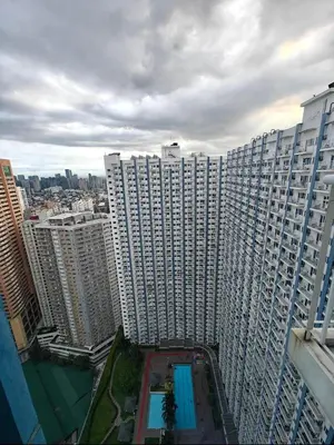 a large building with a pool in front of it at Cozy Modern 1BR Light Residences with 55 inches 4K TV in Manila