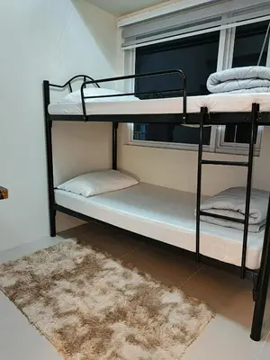 two bunk beds in a room with a rug at SMDC Jazz Residence by rhoda kotani in Manila