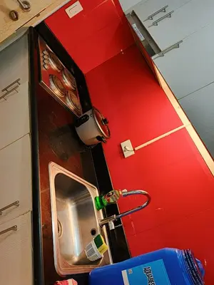 a kitchen with a sink and a red wall at SMDC Jazz Residence by rhoda kotani in Manila