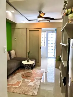 a living room with a couch and a table at SMDC Jazz Residence by rhoda kotani in Manila