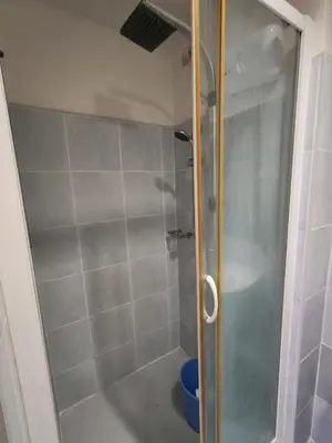 a shower with a glass door in a bathroom at Sea Residences near moa Glenda in Manila