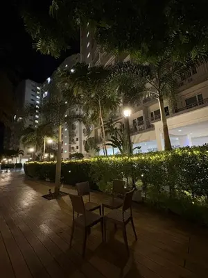 a table and chairs on a patio at night at Cozy Sunset Condo Thompson Stay in Manila