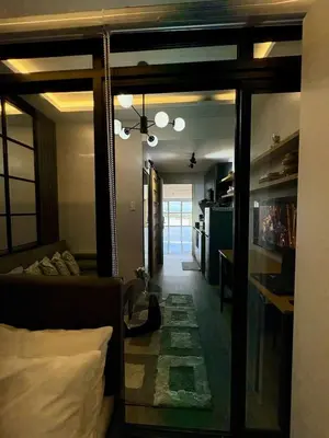 a room with a bed and a living room with a mirror at Cozy Sunset Condo Thompson Stay in Manila