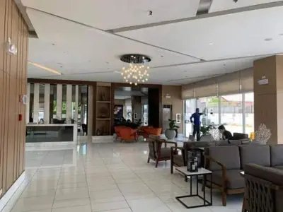 a lobby with chairs and tables in a building at Cozy Sunset Condo Thompson Stay in Manila