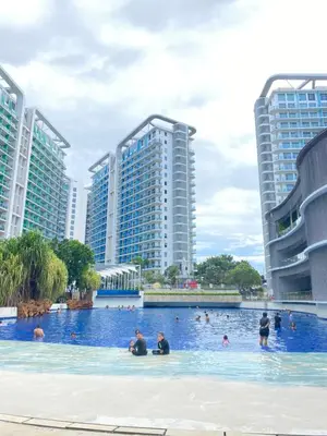 a group of people in a swimming pool with tall buildings at Azure Urban Resort Residences in Manila