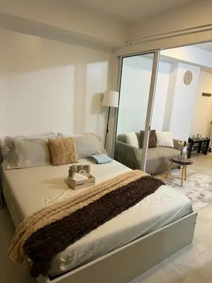 a bedroom with a large bed with a large window at Azure Urban Resort Residences in Manila