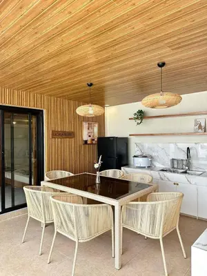 a dining room with a table and chairs and a kitchen at Light residence in Manila