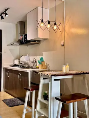 a kitchen with a counter and a kitchen island with stools at Light residence in Manila