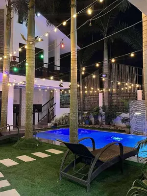 a swimming pool with a bench next to a building with lights at Light residence in Manila