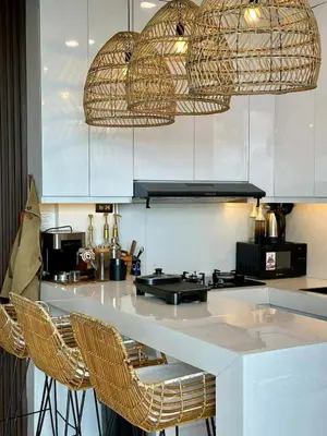 a kitchen with wicker chairs and a counter top at Light residence in Manila