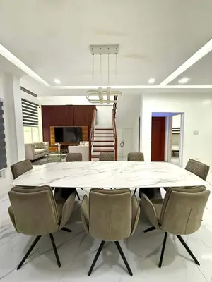 a dining room with a large white table and chairs at Light residence in Manila
