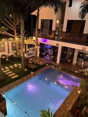 a large swimming pool with lights in front of a building at Light residence in Manila