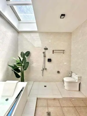 a white bathroom with a toilet and a sink at Light residence in Manila