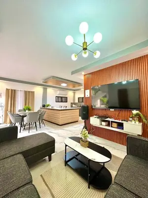 a living room with a couch and a flat screen tv at Light residence in Manila