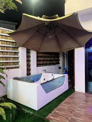 a bath tub sitting under an umbrella on a patio at Light residence in Manila