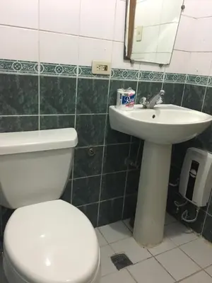 a bathroom with a white toilet and a sink at Studio Condominium near the US Embassy in Manila in Manila