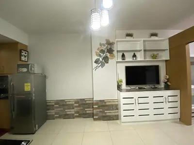 a kitchen with a refrigerator and a television in it at Shell Residences Mall of asia Pham in Manila