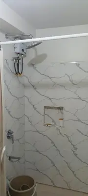 a bathroom with a toilet and a marble wall at One br cozy resort style condo sunset view balcony Robinson Las Pinas in Manila