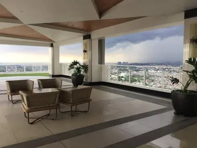 a living room with a view of a city at One br cozy resort style condo sunset view balcony Robinson Las Pinas in Manila