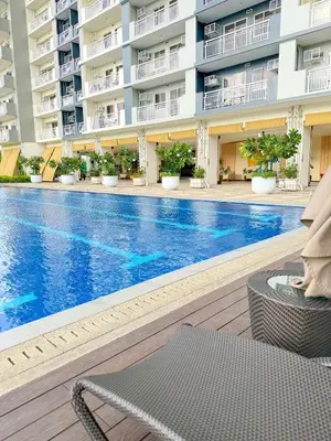 a swimming pool in the middle of a building at One br cozy resort style condo sunset view balcony Robinson Las Pinas in Manila