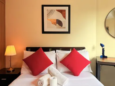 a bedroom with a bed with red and white pillows at Comfy Stays in Shell Residences by OneGuestPlace in Manila