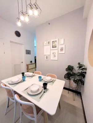 a white dining room with a white table and chairs at Cozy Garden View near Airport WFH Netflix Stay in Manila