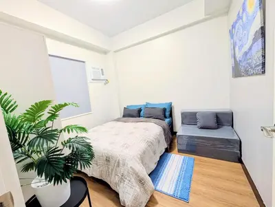 a bedroom with a bed and a plant in it at Cozy Garden View near Airport WFH Netflix Stay in Manila