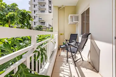 two chairs on the balcony of a building at Cozy Garden View near Airport WFH Netflix Stay in Manila