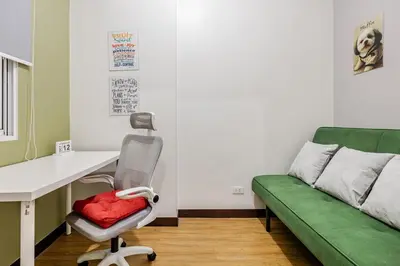 a room with a desk and a green couch at Cozy Garden View near Airport WFH Netflix Stay in Manila