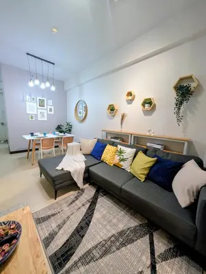 a living room with a couch and a table at Cozy Garden View near Airport WFH Netflix Stay in Manila