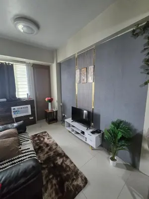 a living room with a couch and a television at Newport Staycation in Manila