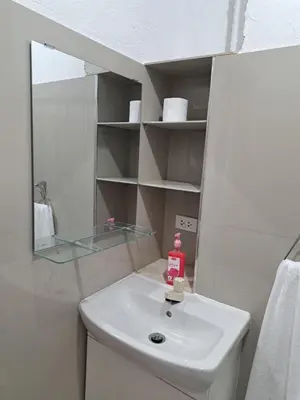 a bathroom with a white sink and a mirror at CORKA Manila in Manila