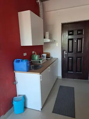 a kitchen with a white refrigerator and a red wall at CORKA Manila in Manila