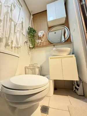 a bathroom with a toilet and a sink and a mirror at Cozy and Comfy Retreat with Balcony in Manila