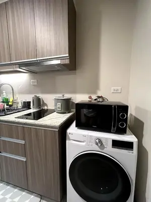 a kitchen with a microwave and a dishwasher at 10L Luxe City Escape at Park Mckinley West in Manila